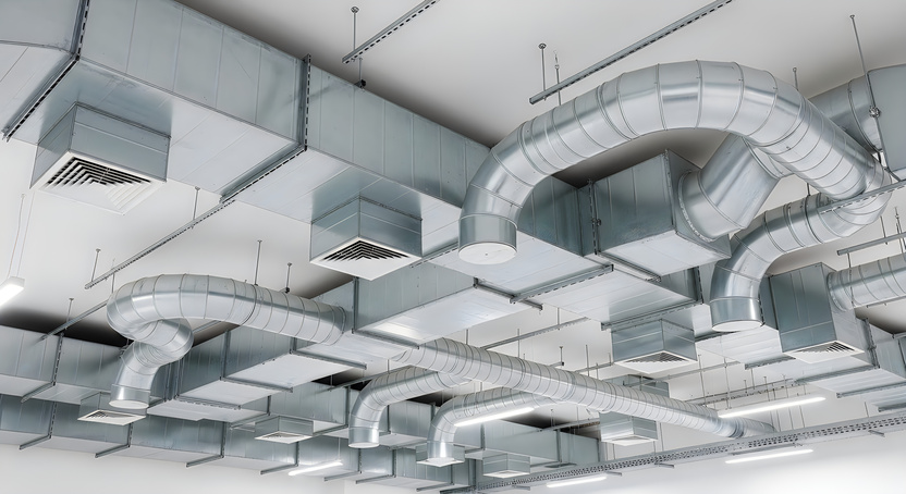 Gaines de ventilation : Réseau de gaines de ventilation en plafond, illustrant les systèmes énergétiques du bâtiment